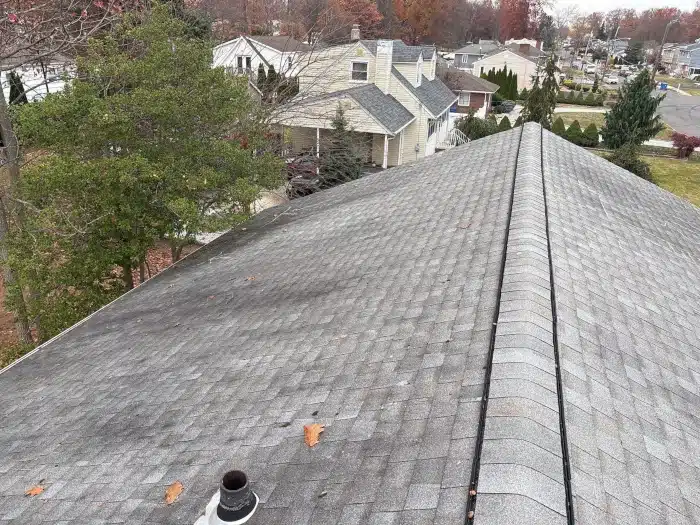 An aging roof with visible wear and discoloration, showing signs that indicate how often to replace roof materials to avoid costly repairs.