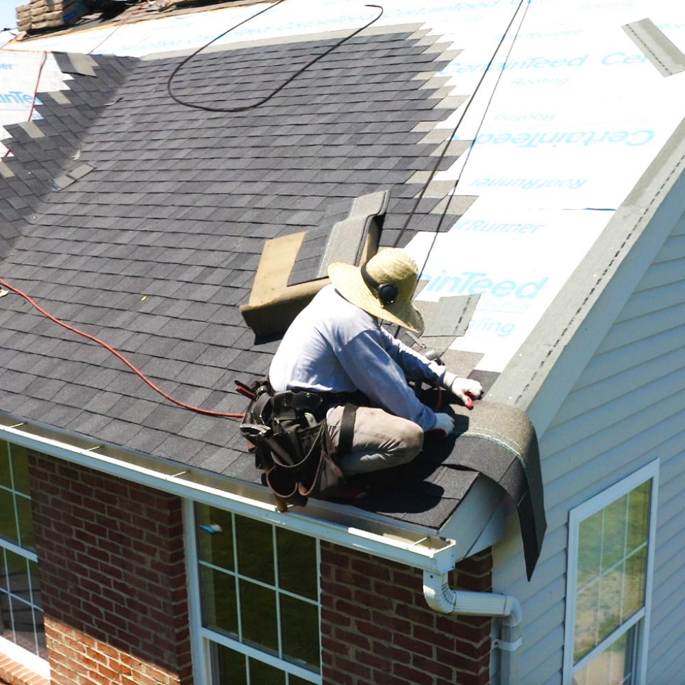 roofer installing roof shingles over certainteed roofing materials.